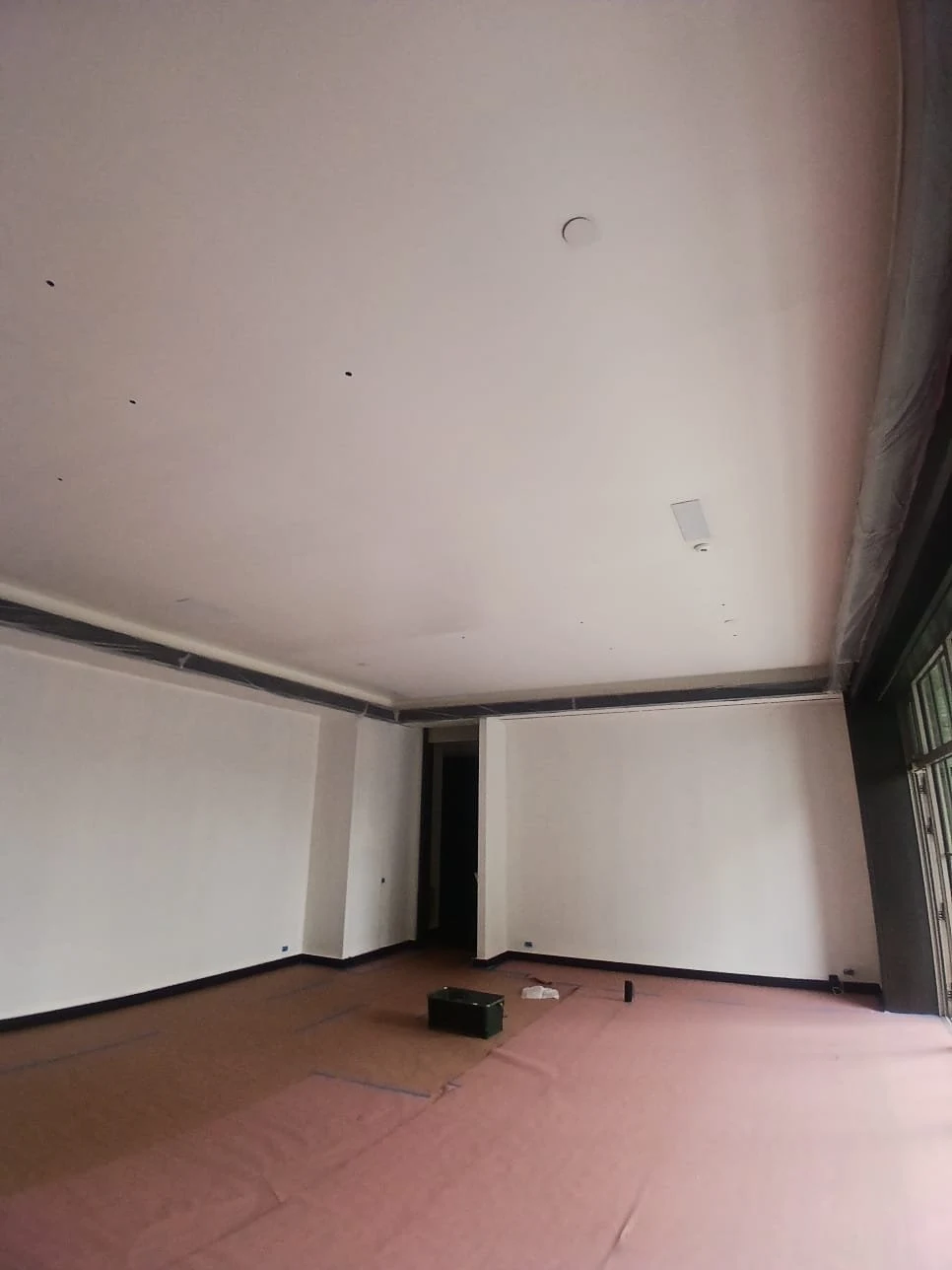 Ceiling-edge trim is masked while surrounding surfaces are prepared and finished.